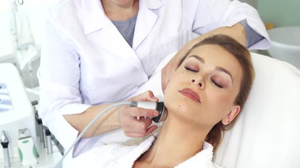 Cosmetologist Makes Facial Massage with Special Equipment