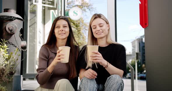 Two Friends Enjoy a Conversation with Tea and Coffee Glasses in Love Outside