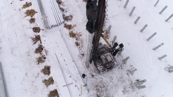 Top down aerial drone view of a pile bore machine at work at winter construction site 23