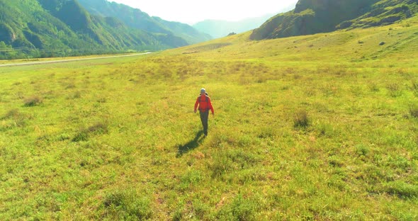 Flight Over Backpack Hiking Tourist Walking Across Green Mountain Field