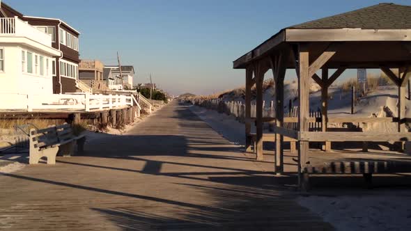 An empty shore town boardwalk late in the day as the shadows get long.