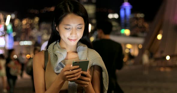 Woman using smart phone at night 