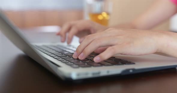 Woman type on computer at home