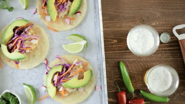 Fresh fish tacos with cod and purple cabbage on a white corn tortillas.