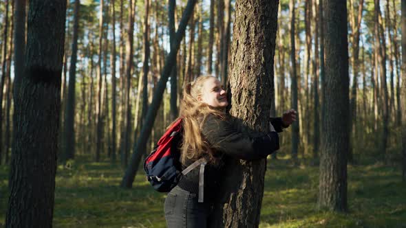 Girl Hugging a Pine Tree and Smiling