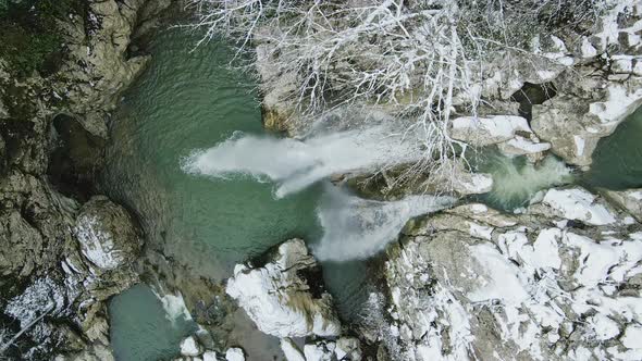 Waterfall Flowing From White Rocks Into a Lake in the Forest