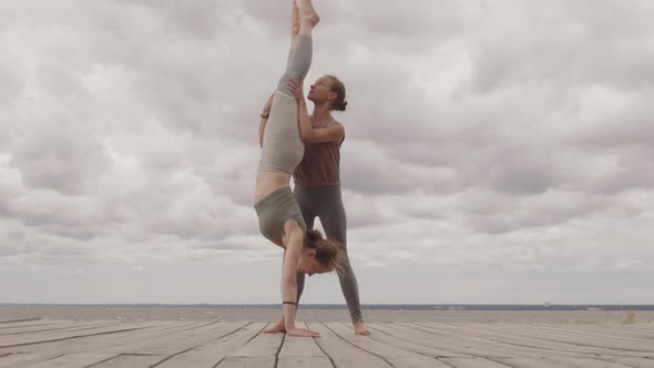 Woman Doing Handstand on Pier