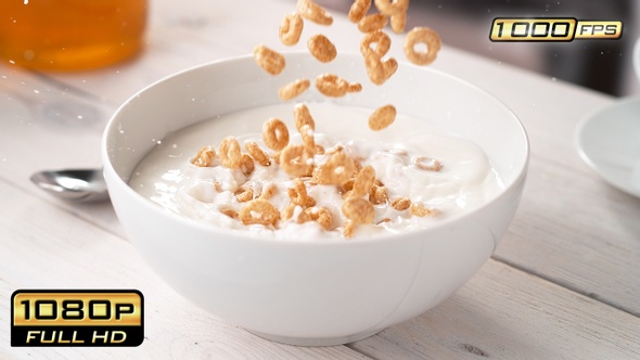 Circle-Shaped Cereals Falling into Bowl with Milk