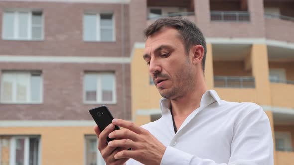 Closeup of a Businessman Working Intently in a Smartphone