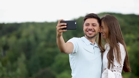 Couple Making Photo On Mobile Phone In Nature