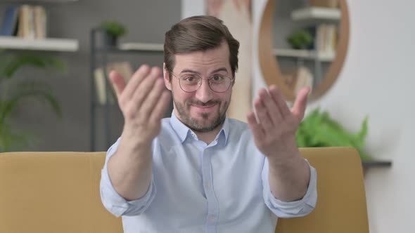 Portrait of Young Man Pointing Towards Camera and Inviting