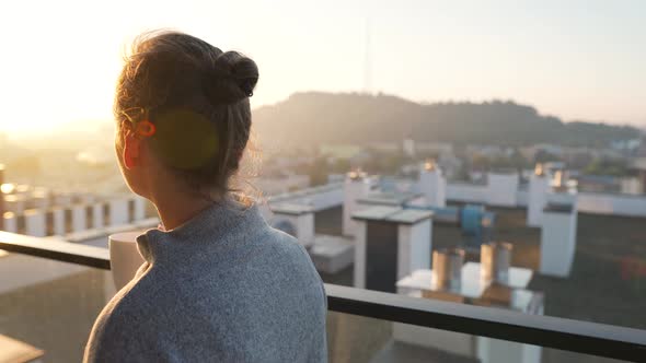 Woman Starts Her Day with a Cup of Tea or Coffee on the Balcony at Dawn Slow Motion