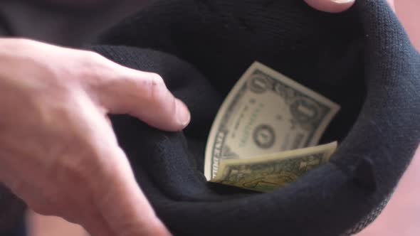 Close-up of a beggar's hat in which he collects donations.