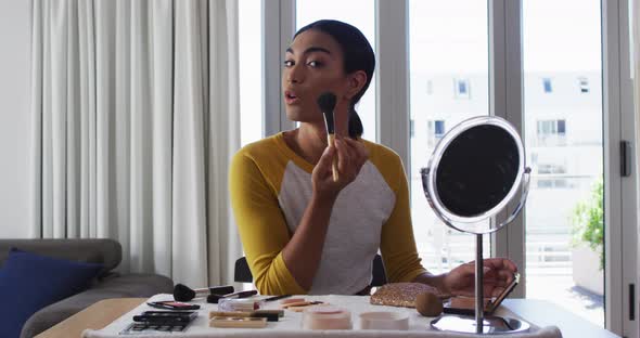 Mixed race gender fluid vlogger recording a make up vlog at home