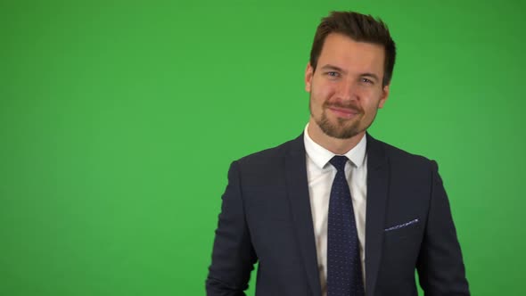 A Young Handsome Businessman Points at the Camera and Nods with a Smile - Green Screen Studio