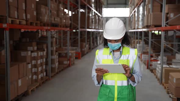 Female Warehouse Worker Taking Inventory on Tablet