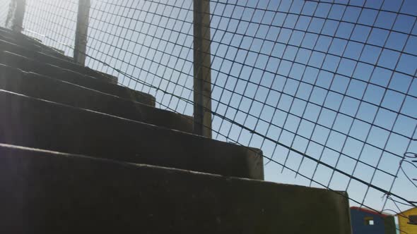 Focused african american man running up the stairs, exercising outdoors on sunny day