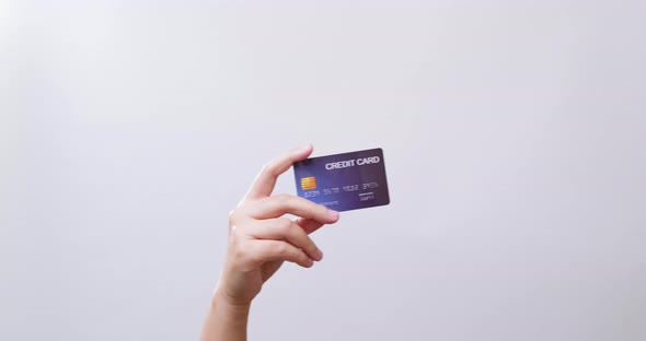 Woman's hand shows a credit card ready for shopping online in white studio background with copy spac
