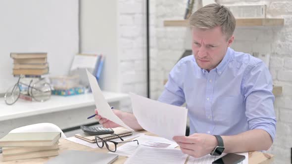 Annoyed Businessman Reading Documents