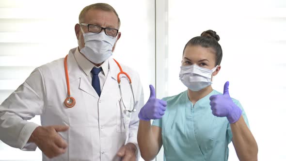 Portrait of an Elderly Male Doctor and a Young Nurse Wearing Medical Masks Showing OK. Professional