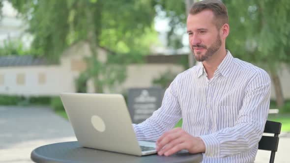 Middle Aged Man Talking on Video Call on Laptop