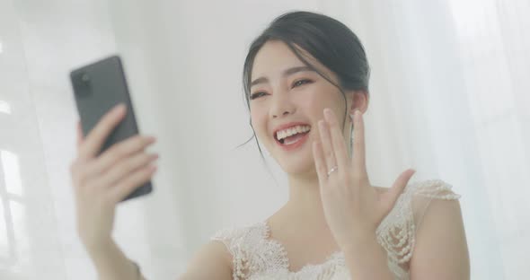 Happy Beautiful Asian Bride Shows Wedding On Her Ring Finger To Her Friend By Smartphone Video Call.