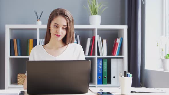 Young Woman Works at Home Office Using Computer.