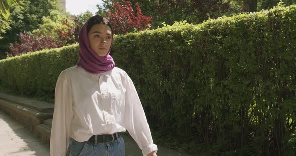 Beautiful Young Woman Walk at the Street, Wearing Traditional Headscarf. Attractive Female in Hijab