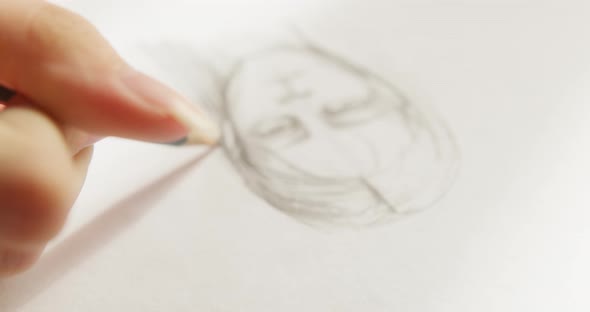 Young Woman Artist Hands Painting Man Portrait on White Paper Using a Pencil Closeup