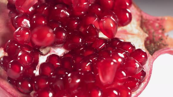 Pomegranate Grains Rolls Down on Surface of Broken Pomegranate in Slow Motion