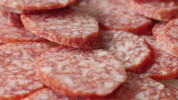 Salami  smaller pieces served on plate food background slow tilt 4K 2160p 30fps UltraHD footage - Ti