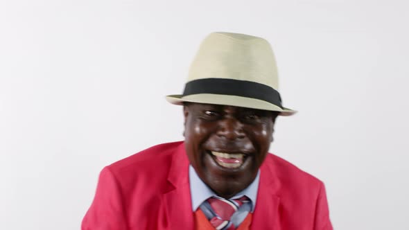 Joyous African Man Laughing and Putting on Hat