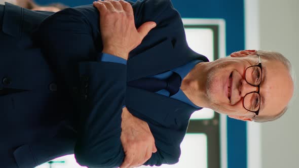 Elderly Businessman Looking at Camera Crossing Arms and Smiling