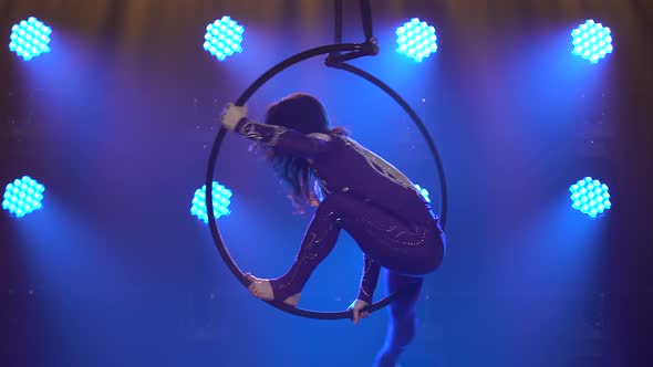 Flexible Woman Hanging in an Aerial Acrobatics Ring Performs Complex Tricks. Aerial Acrobat in a