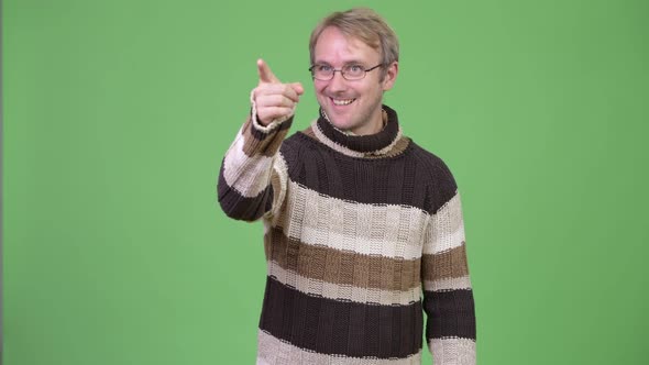 Studio Shot of Happy Handsome Man Thinking While Pointing Finger