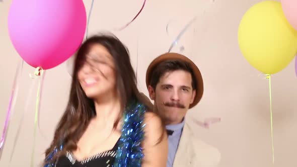 Cute couple having fun dancing in party photo booth