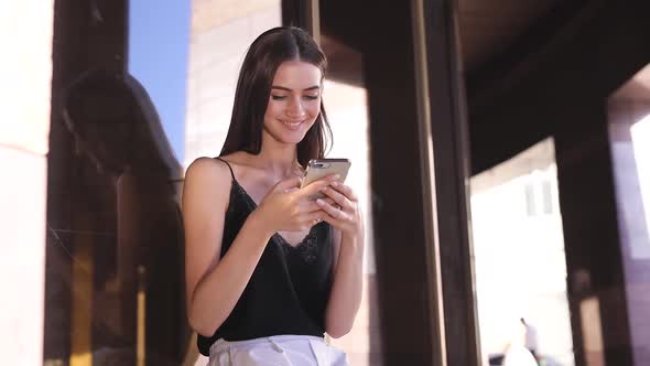 Beautiful Fashionable Woman Using Mobile Phone Near Office