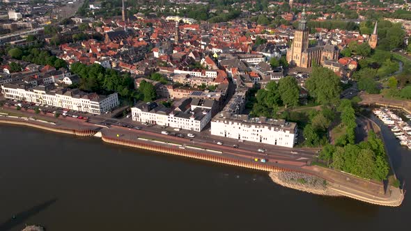 Time lapse showing medieval city seen from above with inland shipping large cargo vessel leaving rip