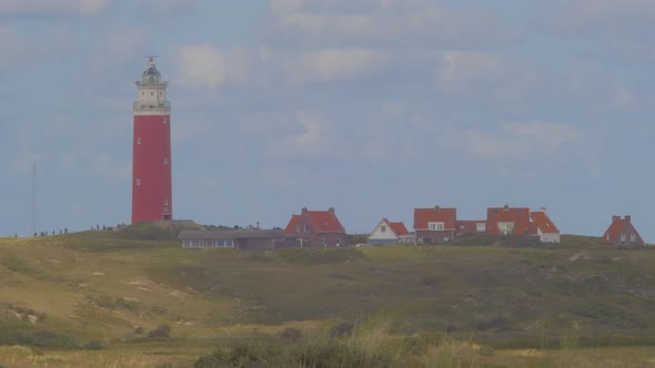 Steady Tele shot of Marram grass in the foreground. In the distance a lighthouse in the dunes togeth