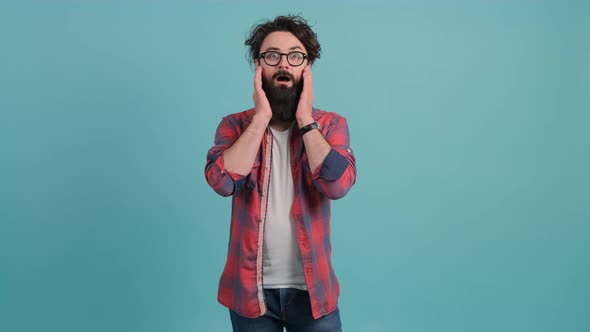 Young Bearded Man Showing Surprise and Amazed Expression with Hands on Face
