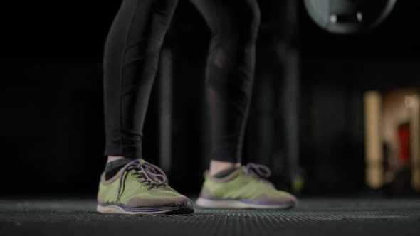 Anonymous Female Performs a Deadlift with Barbell Lifts Barbell and Does Weights Training in the Gym