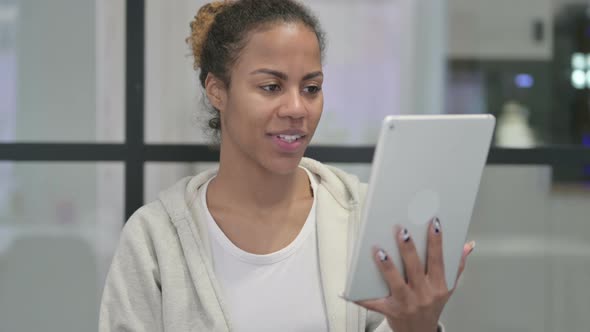 Video Chat on Tablet By African Woman in Office