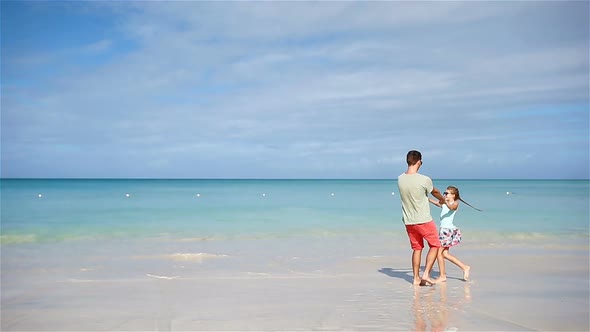 Happy Father and His Adorable Little Daughter at White Sandy Beach Have Fun. Family Enjoy Vacation