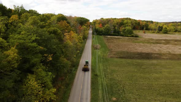 Aerial view of a tractor pulling a trailer through the rural countryside