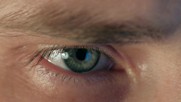Close up of a male eye looking at laptop.