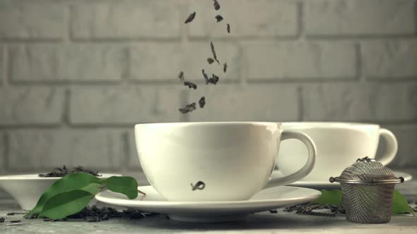 Super Slow Motion in the Cup on the Table Fall Dry Tea Leaves