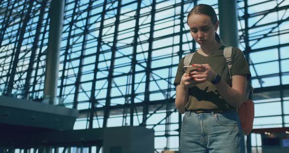 A Woman Looks at the Screen of a Mobile Phone To Find Your E-ticket on the Plane