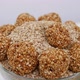 View of dropping sesame ladoo over bowl filled with sesame seeds - VideoHive Item for Sale