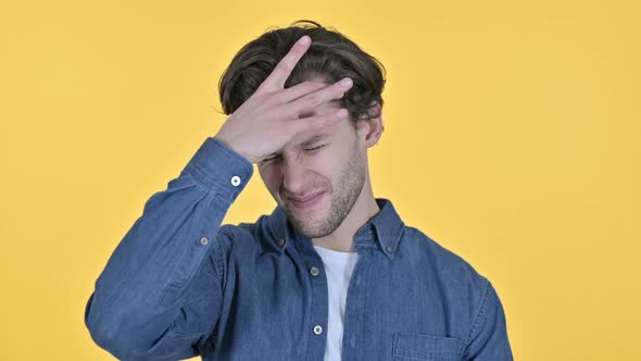 Young Man Having Headache Pain in Head on Yellow Background