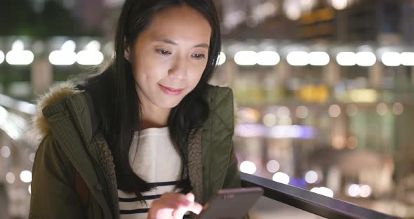 Woman use of smart phone in city at night